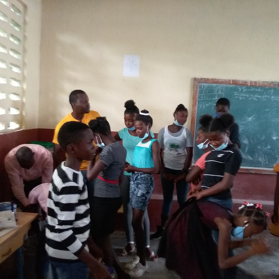 A group of people standing around in a room.