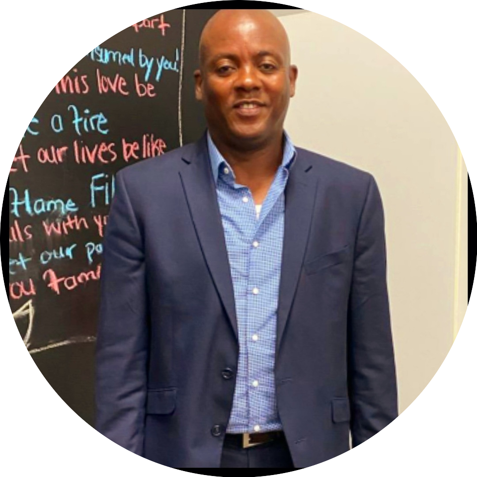 A man in a suit standing next to a chalkboard.