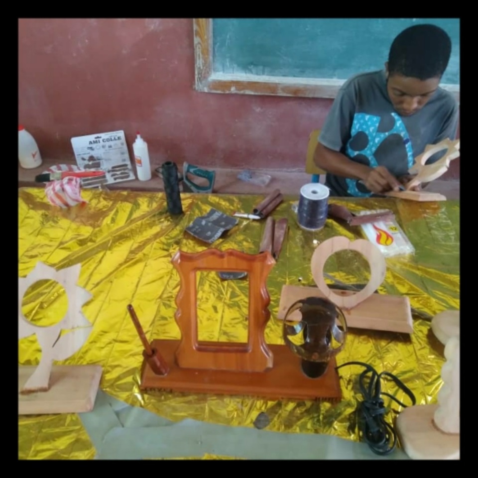 A boy is sitting at the table with some tools.