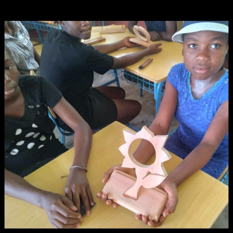 A girl is holding a wooden sun block.