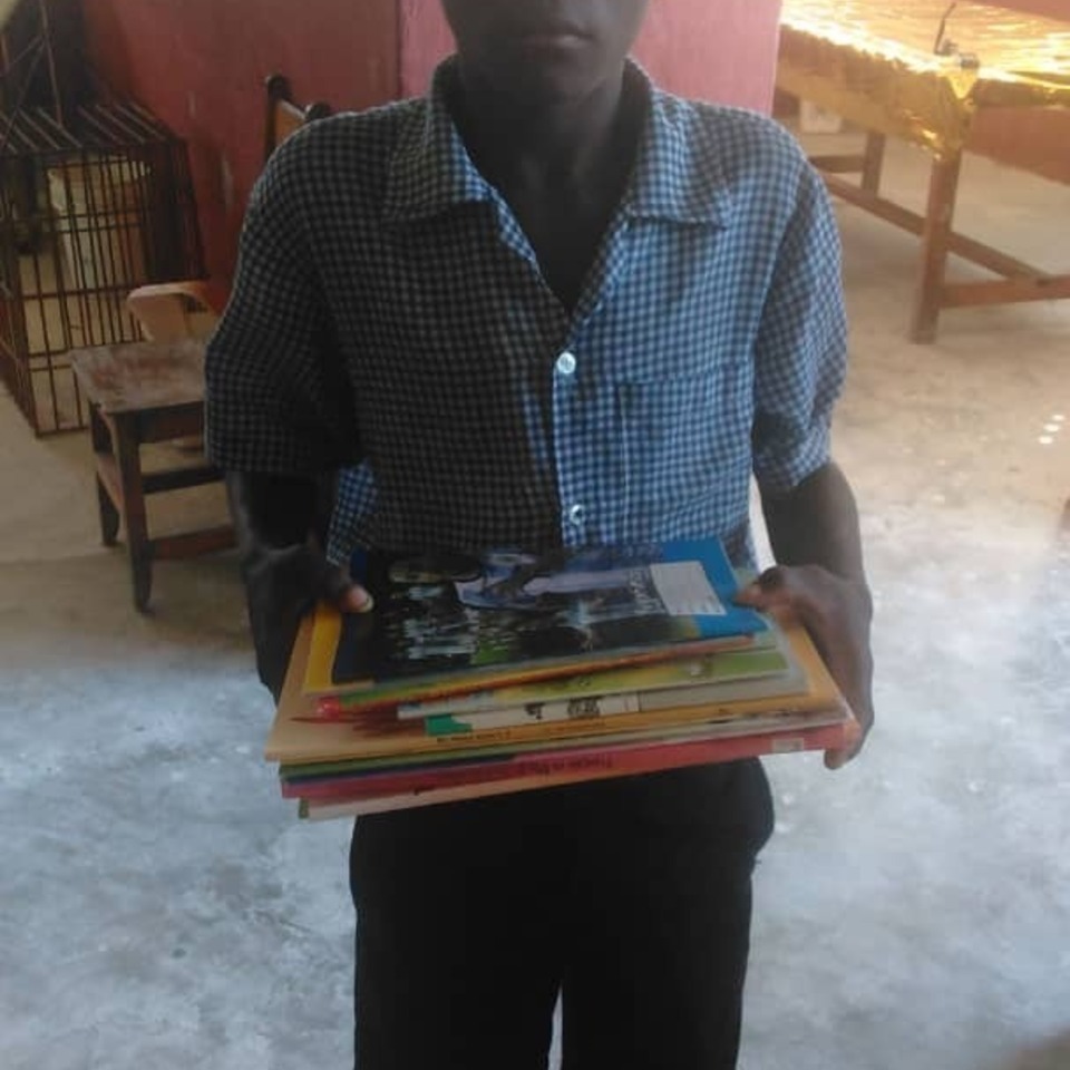 A man holding a stack of books in his hands.