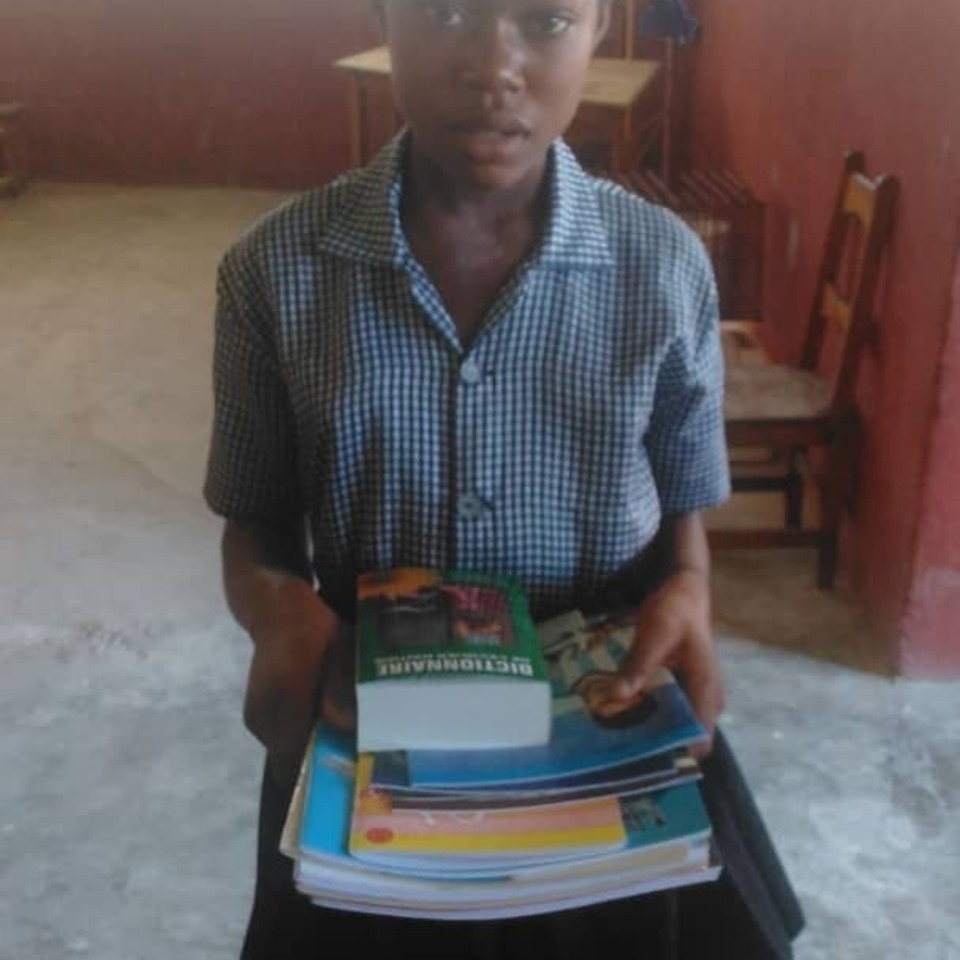 A boy holding some books in his hands