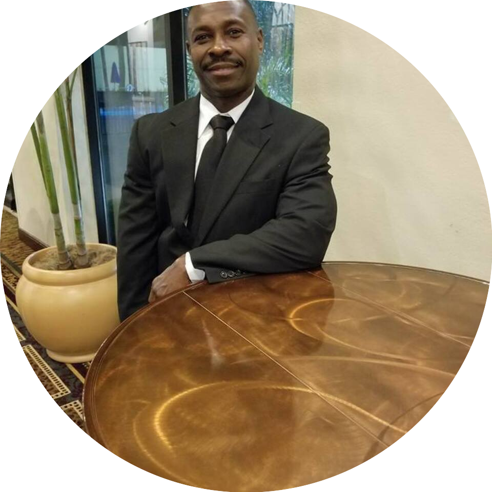 A man in suit and tie sitting at a table.