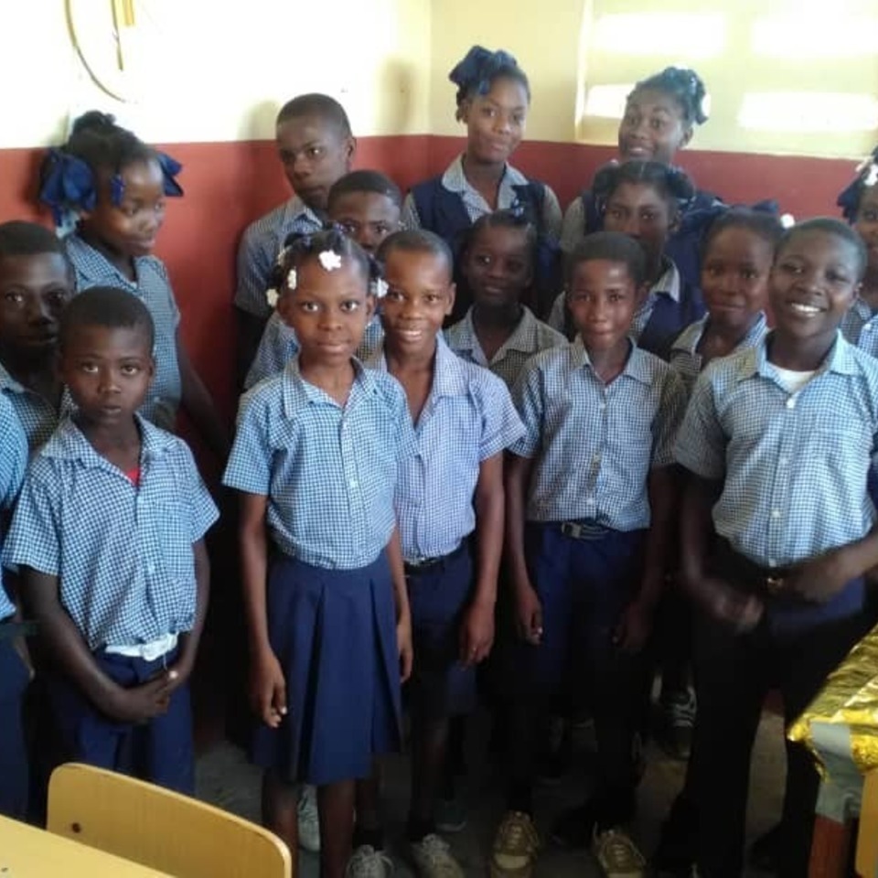 A group of children in school uniforms posing for the camera.