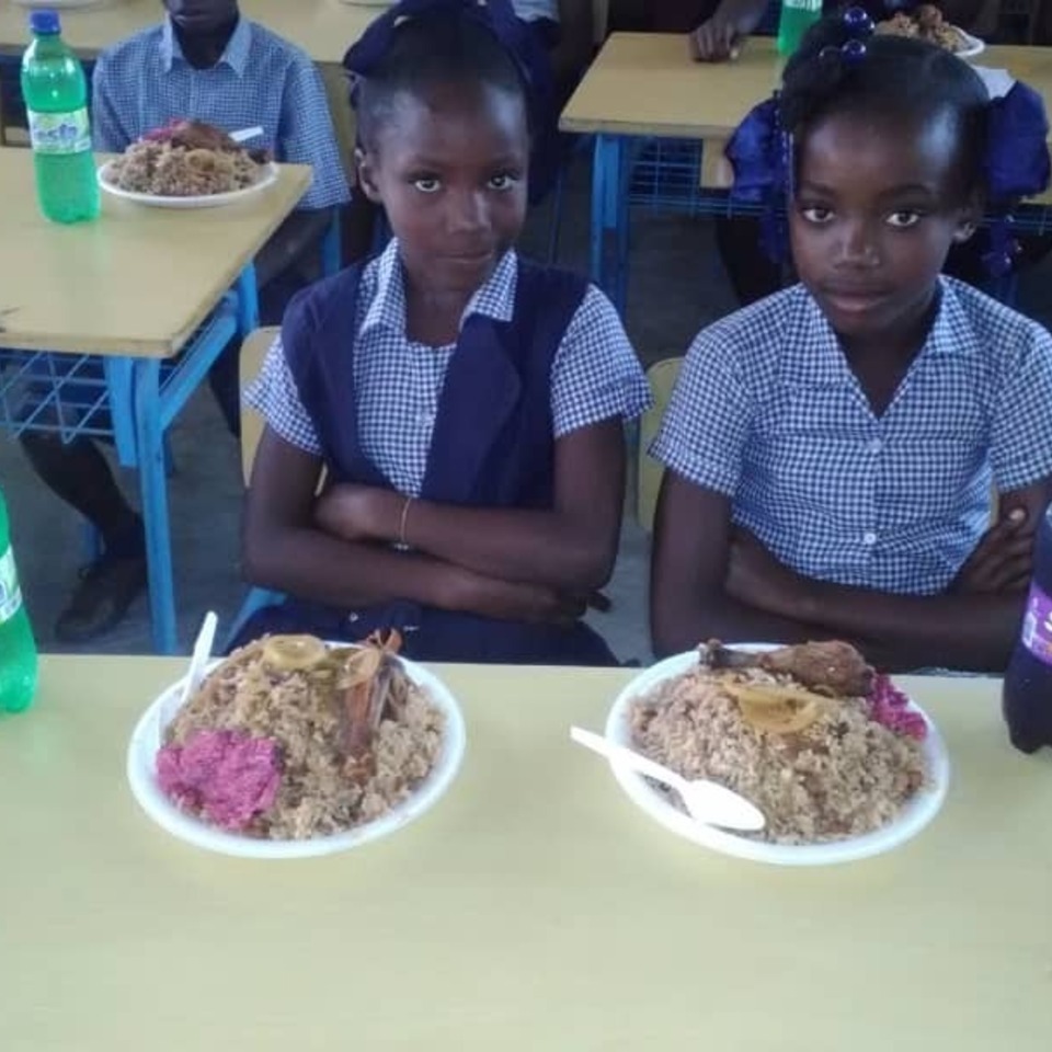 Two students sitting at a table with plates of food.