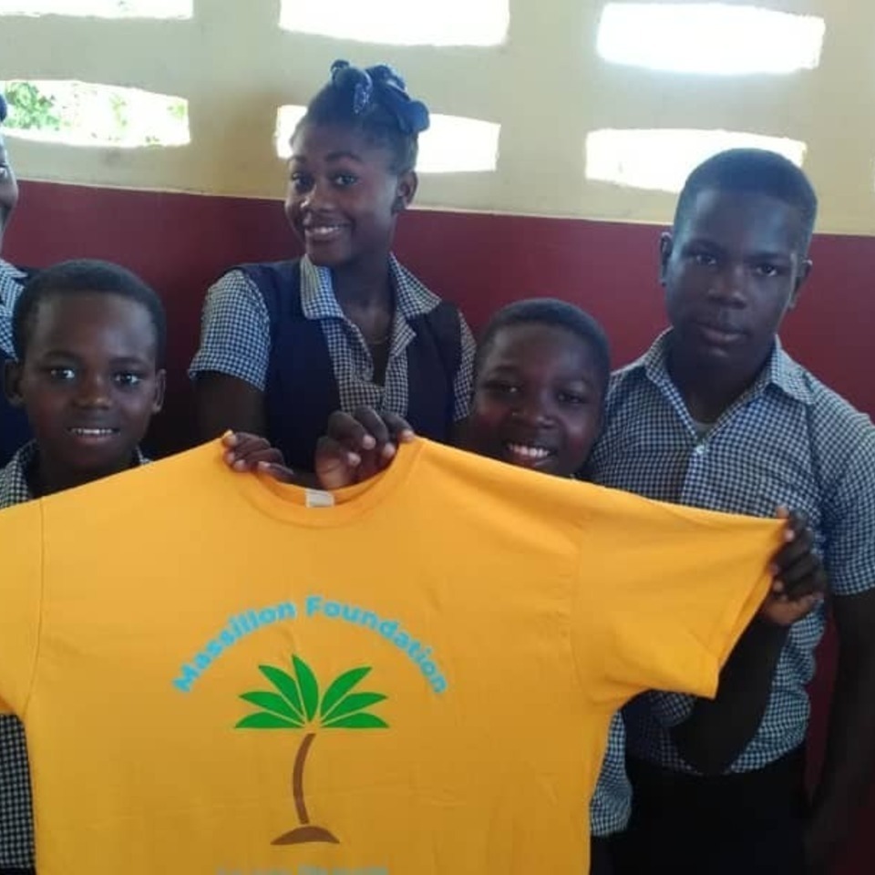 A group of people holding up a yellow shirt.