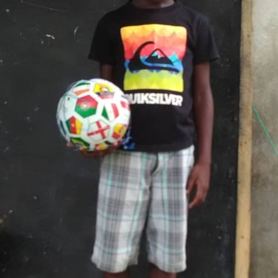 A young boy holding a soccer ball in his hands.