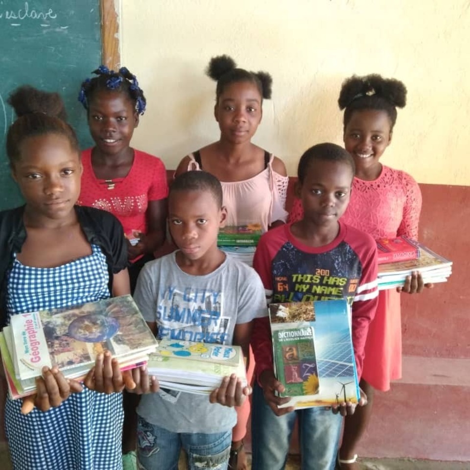 A group of children holding books in their hands.