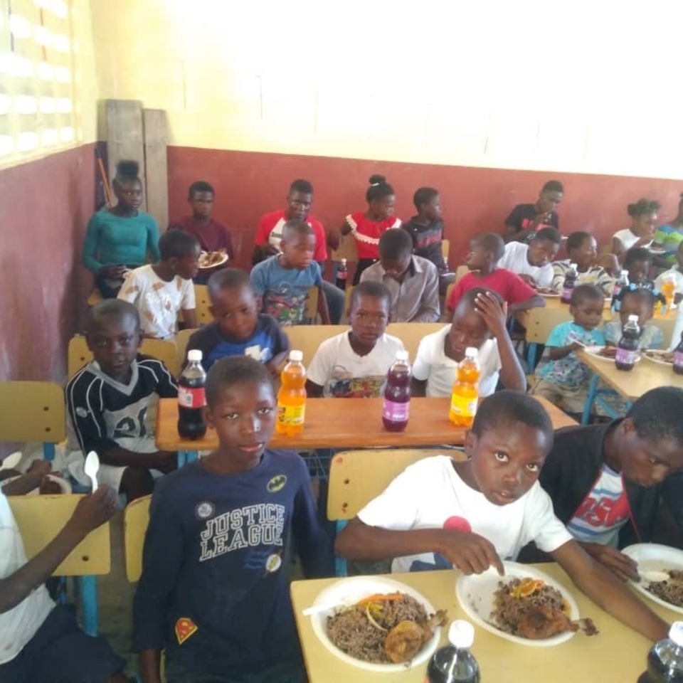 A group of people sitting at tables eating food.