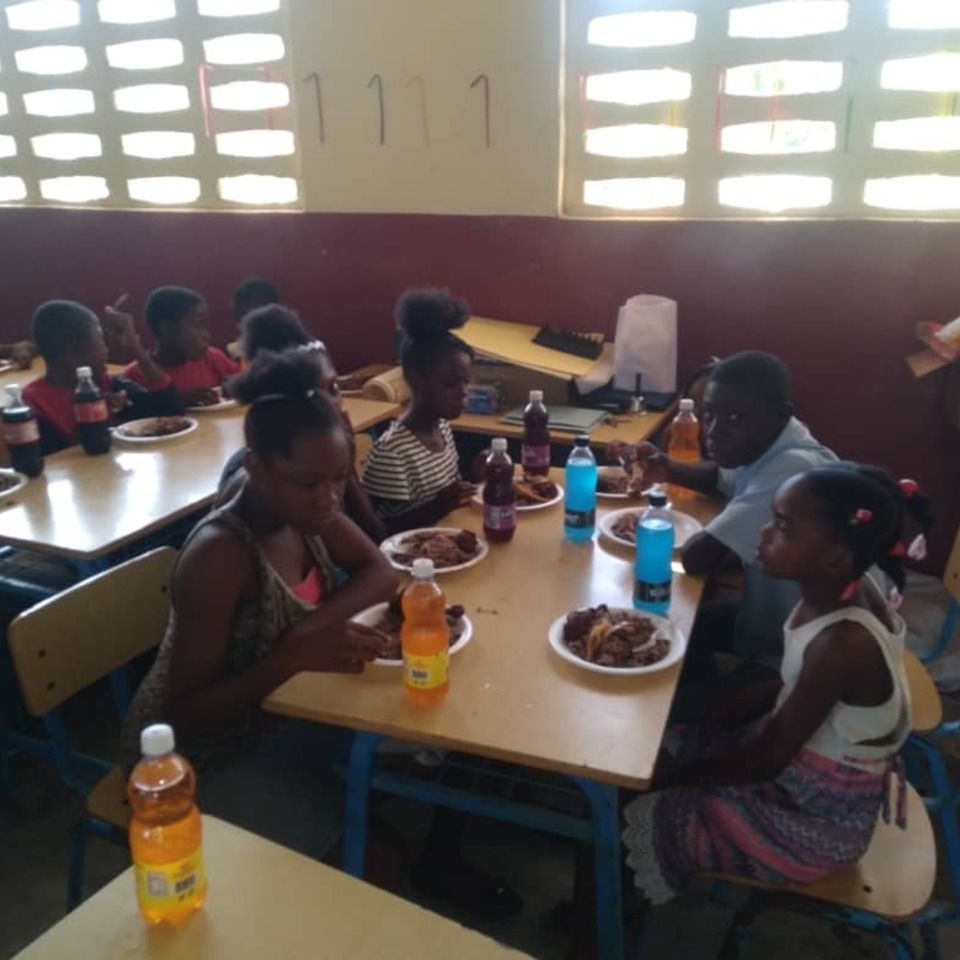 A group of people sitting at tables eating food.