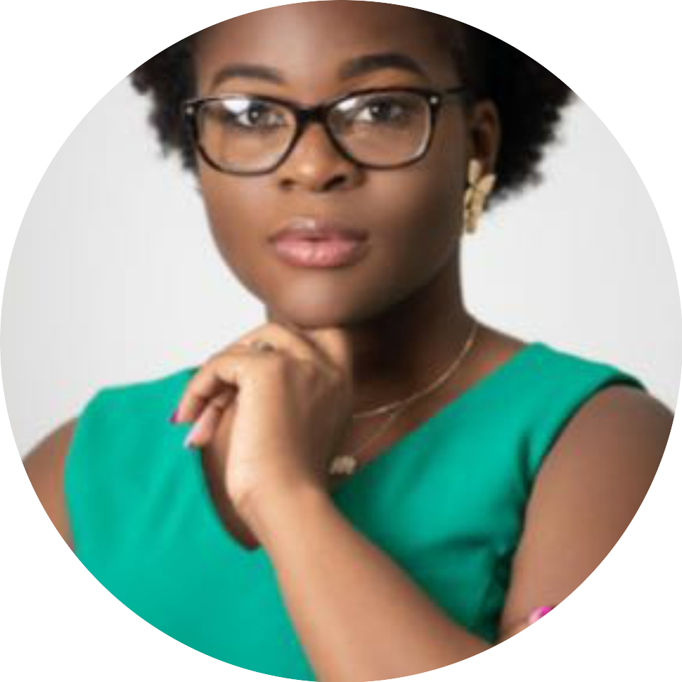 A woman in glasses and green shirt with her hand on her chin.