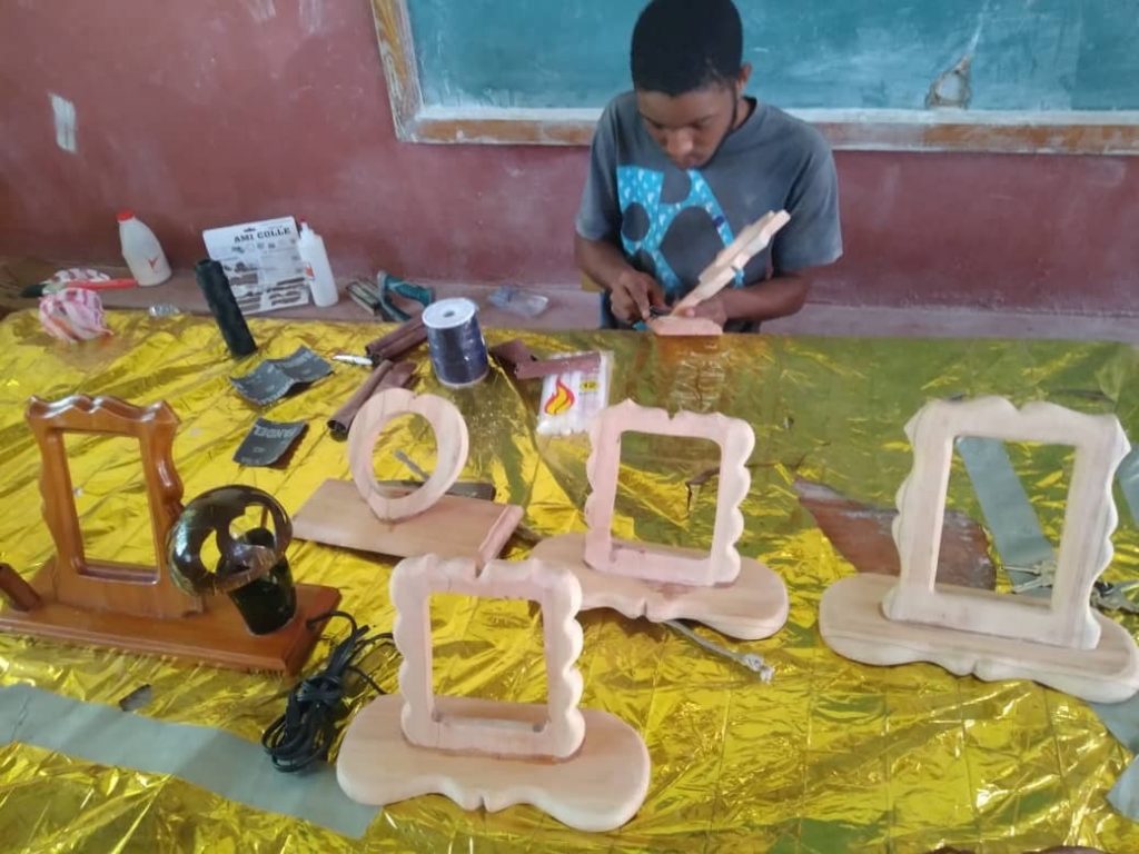 A boy is working on some wooden frames.