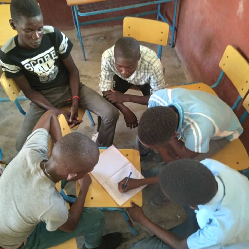 A group of young men sitting around each other.