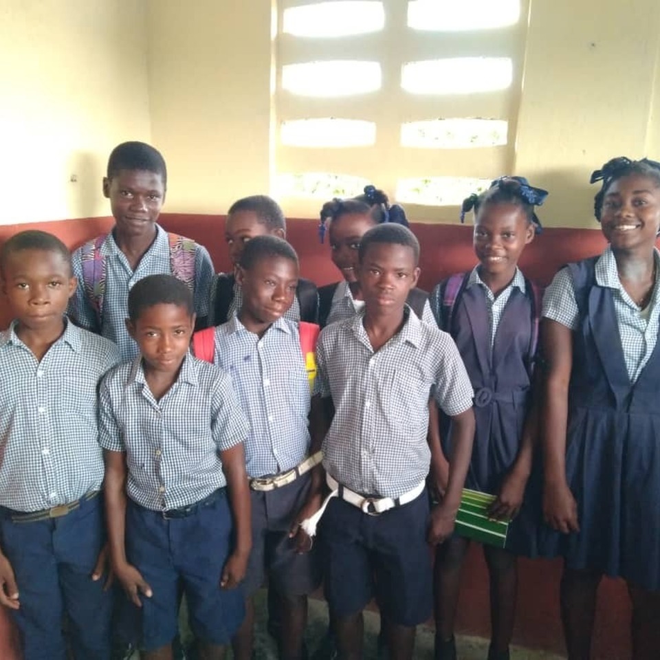 A group of children standing in front of a window.