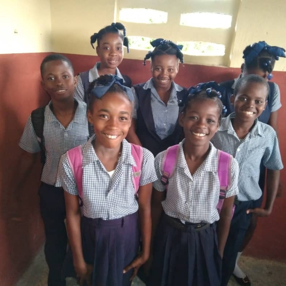 A group of young girls standing in front of a wall.