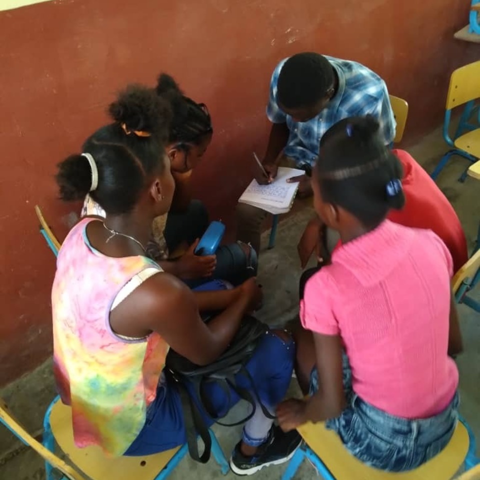 A group of children sitting around each other.