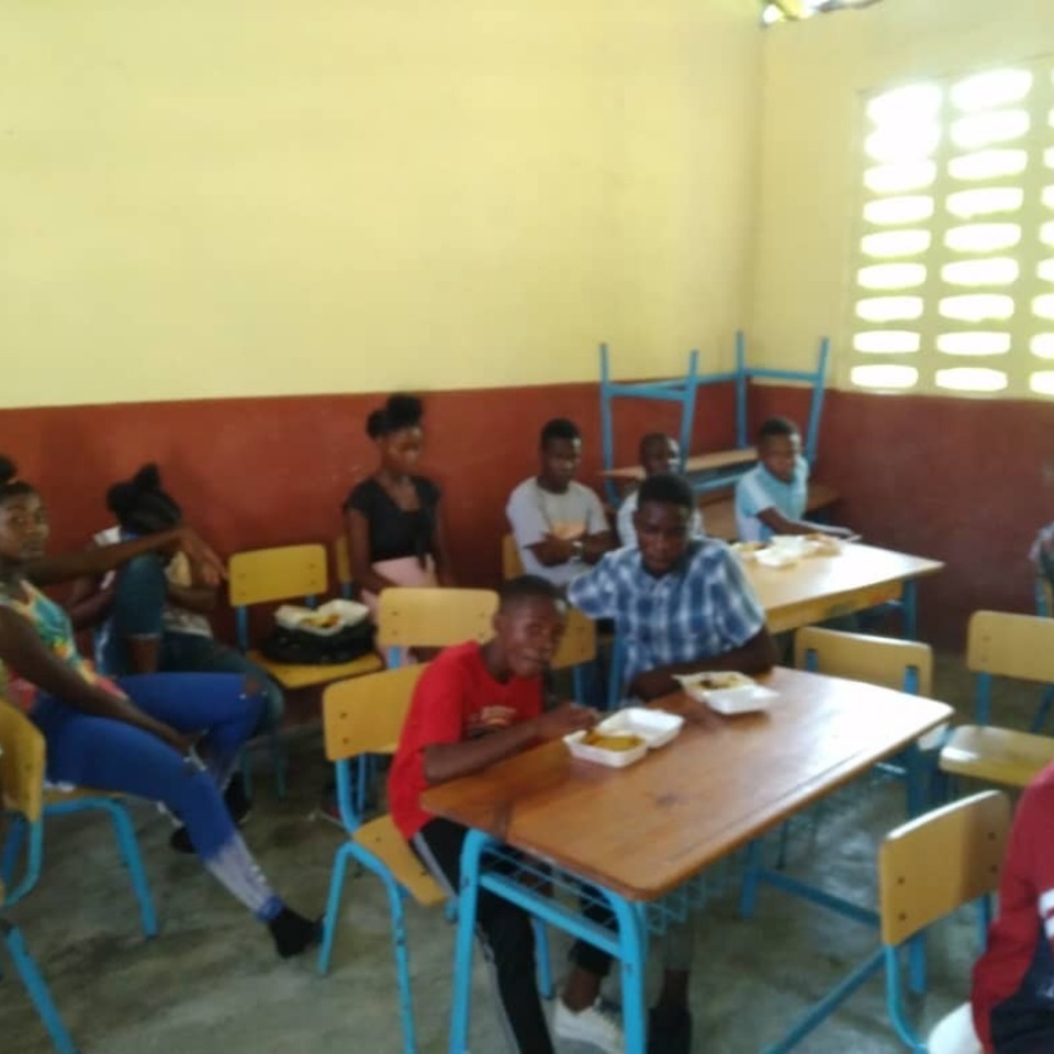 A group of people sitting at tables eating food.