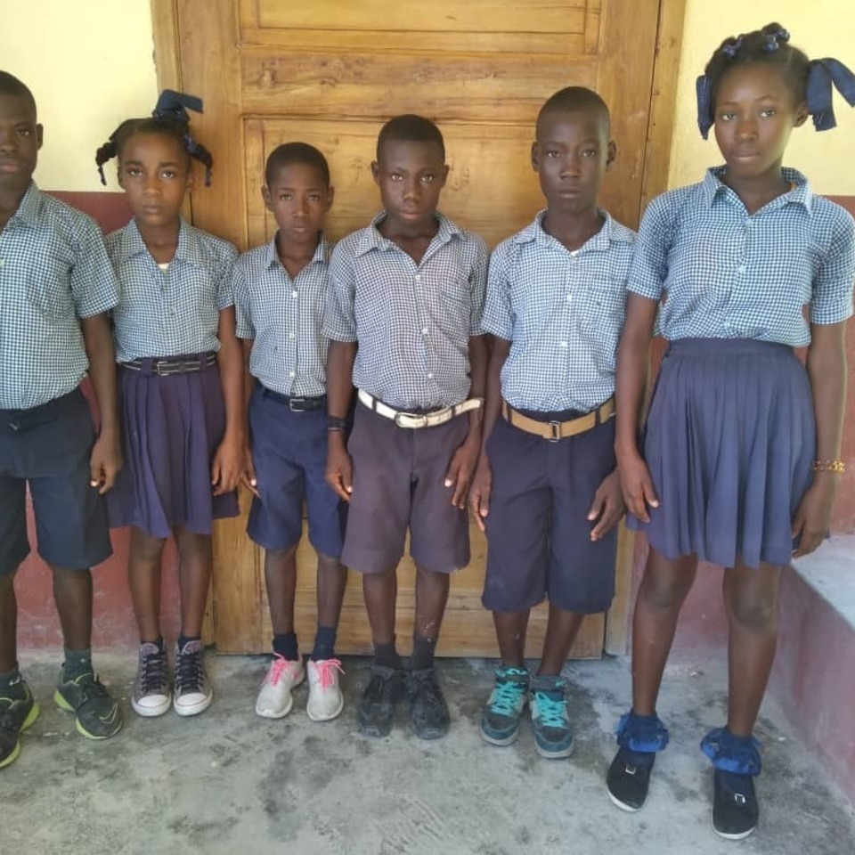 A group of children standing in front of a door.