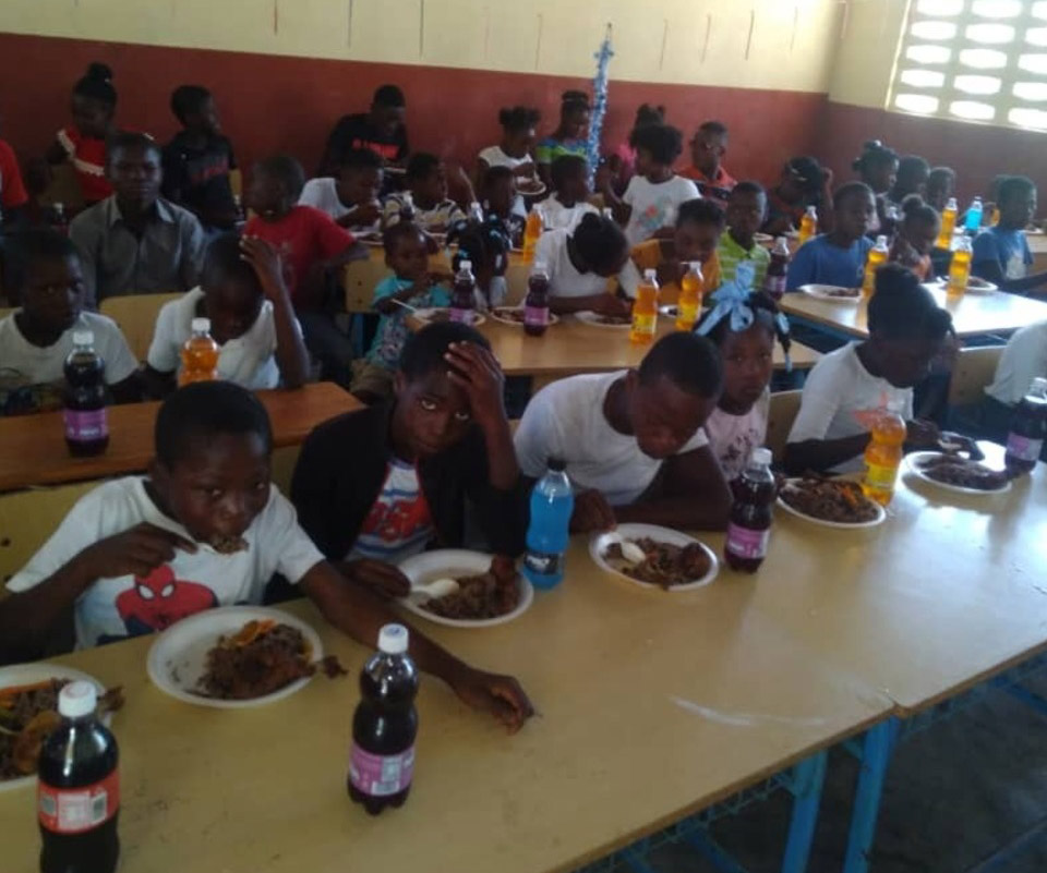 A group of people sitting at a table eating food.