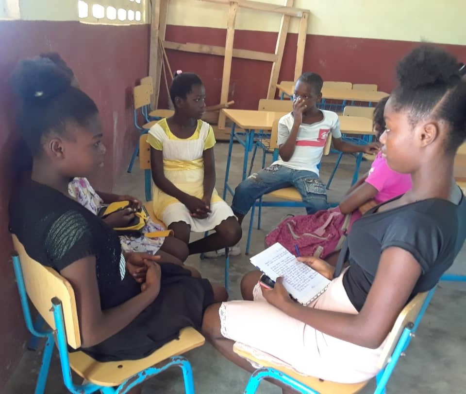 A group of young people sitting in chairs.