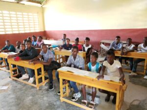 A group of people sitting at desks in a classroom.