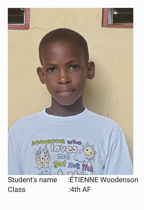 A young boy wearing a white shirt with drawings on it.