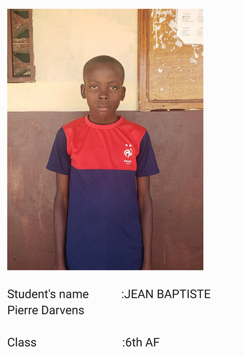 A young boy standing in front of a wall.