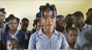 Young girl speaks to a group of students.