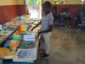 A boy in front of books kept on table